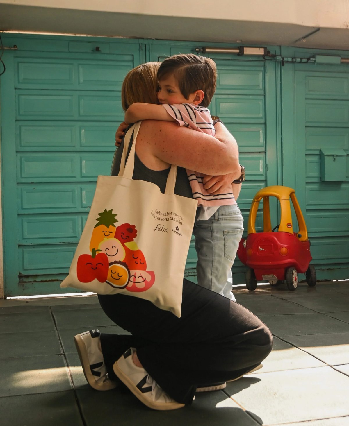 Mamá con la tote Ensamble abrazando a su hijo